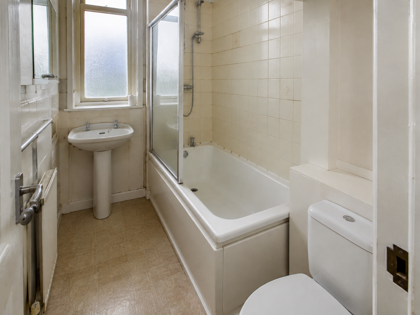 Compact bathroom with a pedestal basin and fitted bath